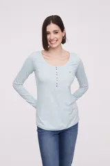 Remera de color celeste con botones frontales y diseño ajustado, de manga larga.