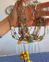 Collar corto de cuentas de colores con dije de pez de cerámica, piedras naturales y detalles en plata 925.