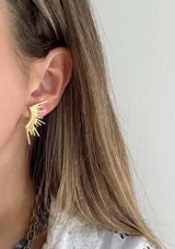 Caravanas de acero dorado con diseño de rayos, elegantes y llamativas.