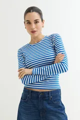 Remera de manga larga ajustada al cuerpo, con cuello redondo, confeccionada en tejido acanalado a rayas horizontales azules y blancas.
