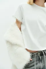 Remera blanca de algodón con cuello redondo y mangas cortas con detalle de puntilla.