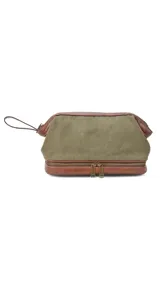 Neceser verde de tela canvas combinado con símil cuero marrón. Tiene apertura superior con cierre metálico estructural, doble bolsillo interno (uno con cierre y otro abierto con división) y base con cierre que actúa como bolsillo extra.