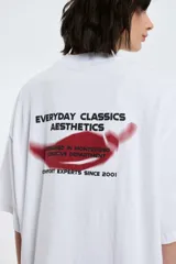 Remera blanca de algodón con cuello redondo y manga corta. Estampado pequeño de un ají rojo en el centro del pecho.