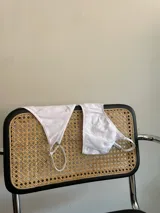 Conjunto de bikini blanco con textura acanalada, compuesto por un corpiño triangular con tirantes finos y una tanga de tiro bajo.