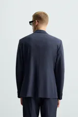 Blazer regular fit de hombre confeccionado en tejido con lana. Cuello con solapas de muesca, manga larga con puño abotonado, bolsillo de vivo en pecho, bolsillos de solapa en cadera, bolsillo interior, bajo con aberturas en espalda y cierre frontal de botonadura.