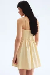 Vestido corto color crema, de algodón, con breteles finos, escote corazón, cuerpo entallado, espalda fruncida y falda con vuelo.