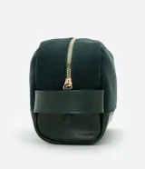 Neceser rectangular mediano de terciopelo verde oscuro con textura acanalada, cierre de cremallera dorada y asa lateral de cuero sintético.