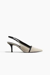 Zapato destalonado color beige con puntera fina y ribete negro. El taco es fino y mide 7 cm.