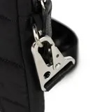 Bandolera mini negra de PU símil cuero, con correa regulable, herrajes plateados y cierre superior. Tiene un compartimento principal y un bolsillo interno con cierre.