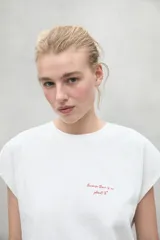 Camiseta blanca de manga corta con texto rojo "Because there is no planet B" en el frente.