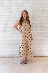 Camisola midi color beige con estampado de lunares negros, cuello camisero, sin mangas y abotonada al frente.