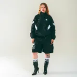 Campera deportiva unisex confeccionada en nylon liviano color negro con paneles diagonales blancos en las mangas y micrográficos Kaboa aplicados al frente. Tiene calce relajado y estructura clásica.