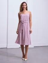 Vestido midi de gasa color lila con estampado de lunares blancos, escote en V, breteles finos regulables, espalda elastizada, delantera plisada con botones forrados y forro interno a tono.