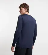 Remera deportiva de manga larga color azul marino, con cuello redondo y detalles reflectantes en franjas verticales en la parte superior del brazo.