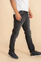 Pantalón de jean gris oscuro, corte slim fit, con bolsillos delanteros y traseros.