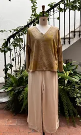 Remera de manga larga color beige con estampado botánico verde y amarillo, escote en V, corte ajustado y tajos laterales.