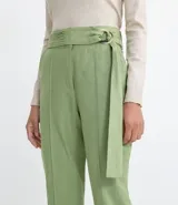 Pantalón zanahoria color verde claro, de tiro alto, con cinturón de la misma tela y hebilla doble.
