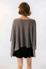 Blusa beige de tejido brillante, con cuello bote y mangas murciélago.