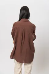 Camisa marrón de lino, corte oversize, con cuello clásico y mangas largas.