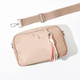 Bandolera de tela color rosado, con cierre y tiradores decorativos.