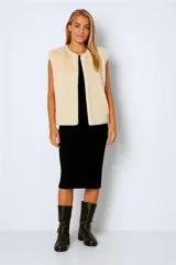 Chaleco largo de piel sintética color beige, sin mangas y con cuello redondo.