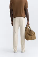 Pantalón chino azul marino, corte skinny fit, confeccionado en tejido de algodón con elasticidad. Cuenta con bolsillos frontales y traseros de vivo. Cierre frontal con cremallera y botón.