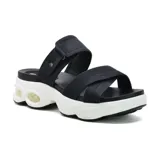 Sandalias negras con plataforma blanca y suela con burbujas de aire. Presentan dos tiras anchas cruzadas sobre el empeine y una tira ajustable con hebilla en el tobillo.