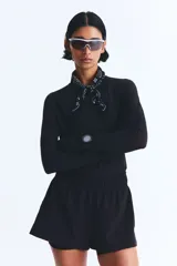Short de correr negro de doble capa, con cintura elástica y cordón ajustable. Cuenta con una abertura lateral y un short interior con bolsillo en una pierna.