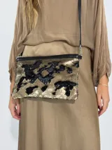 Cartera con superficie de lentejuelas de doble cara que cambian de color al tacto, con bordes de cuero.