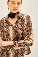 Camisa de manga larga con estampado de reptil, corte masculino y cuello camisero.