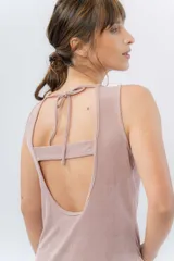 Musculosa color rosa metalizado, sin mangas, confeccionada en lino metalizado, con escote cerrado al frente y espalda abierta con lazo ajustable.