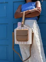 Matero con forma de balde, confeccionado en material símil cuero beige con estampado de rayas verticales en verde militar. Posee bolsillo frontal, asa de mano y correa larga desmontable.