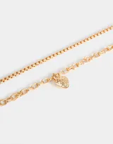 Collar corto dorado con tres cadenas de diferentes grosores y dije de frutilla.