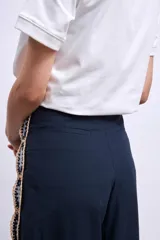 Pantalón palazzo azul marino con apliques bordados de hojas en los laterales.