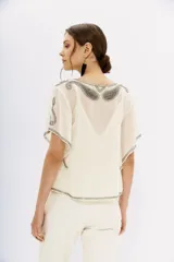 Blusa color crema de georgette con bordado de piedras, mostacillas y canutillos. Tiene viso interior con puntilla.
