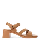 Sandalias de cuero sintético color beige, con tiras anchas cruzadas en el empeine, pulsera con hebilla al tobillo y taco cuadrado.