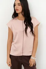 Blusa de manga corta color rosa pálido con textura satinada y costura central vertical en contraste.