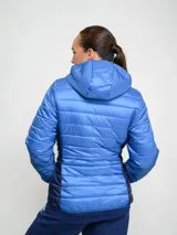Campera puffer azul con capucha y cierre frontal. Tiene el logo de Umbro bordado en el pecho y el escudo del Club Nacional de Football.