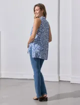 Blusa sin mangas estampada en blanco y azul, con escote en V, pliegue delantero y tajo en costuras laterales.