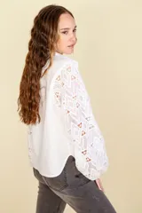 Camisa azul con cuello mao y mangas largas caladas con diseño geométrico.