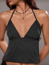 Top halter negro con rayas verticales blancas, escote en V pronunciado y espalda descubierta.