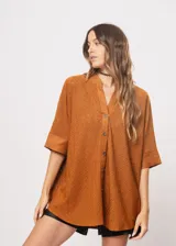 Camisa marrón con calados, escote en V, abotonada y manga 3/4.