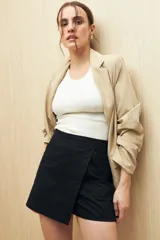 Short pollera color verde militar, de tiro alto, con solapa frontal que simula una falda y bolsillos delanteros.