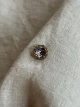 Caravana de resina color lila con strass plateado alrededor, de 1cm de diámetro. Se vende por unidad.