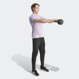 Remera de entrenamiento Adidas de corte ajustado, color lila jaspeado, con cuello redondo y logo de las tres barras en negro en el pecho.