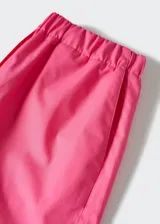 Short de tejido ligero color fucsia, con cintura elastizada y bolsillos laterales.