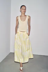 Falda midi de tiro alto confeccionada en hilatura de algodón con estampado geométrico en tonos rosa, marrón y bordó. Detalle de pliegues en cintura y bajo evasé. Cierre con cremallera oculta en costura.