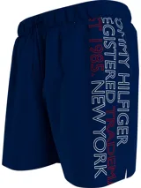 Short de baño azul marino con cintura elástica ajustable con cordón. Estampado vertical con el logo de Tommy Hilfiger en blanco y rojo en la pierna derecha.