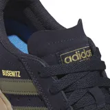 Championes Adidas Busenitz Vulc II, color azul marino con detalles en verde militar y suela color caramelo. Zapatillas de skate de caña baja con exterior de gamuza, las 3 tiras clásicas de Adidas en los laterales y refuerzo Adituff en la puntera para mayor resistencia al desgaste.