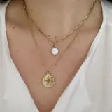 Colgante doble dorado con cadena de eslabones grandes y cadena fina. Incluye dije de perla de imitación y dije redondo con diseño de destello.